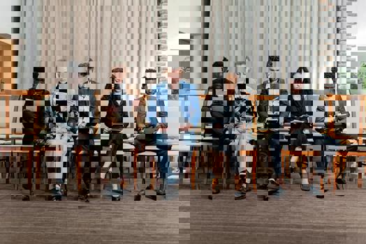 Jobbkandidater sitter bredvid varandra på stolar och läser sina testresultat.